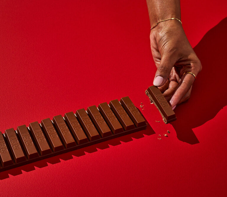Hand breaking piece off chocolate bar