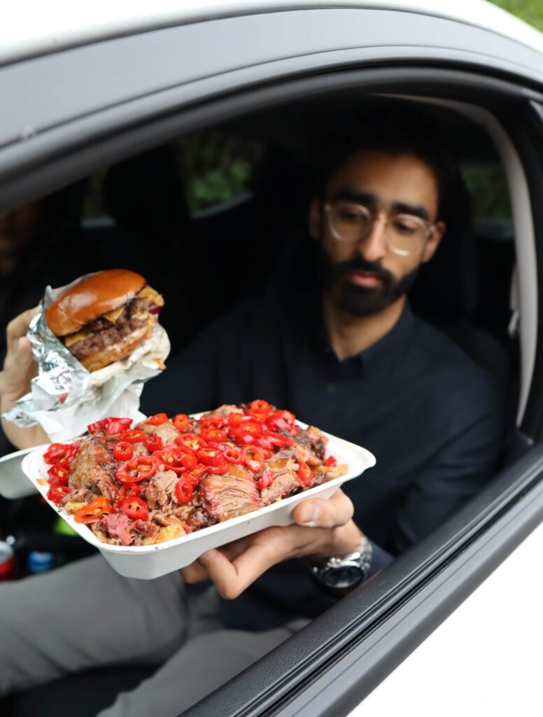 Man holding loaded chips out of car window